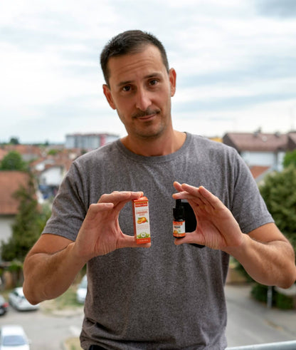 Man holding two bottles of Formula Swiss CBD oil in MCT oil with orange aroma